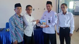 Didampingi kepala SMA Muhammadiyah 1 Jombang, Dian Sukarno menyerahkan buku karyanya kepada pengawas