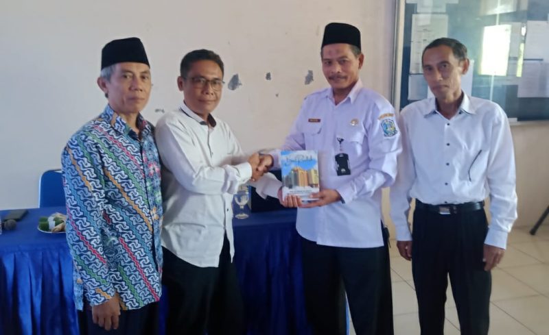 Didampingi kepala SMA Muhammadiyah 1 Jombang, Dian Sukarno menyerahkan buku karyanya kepada pengawas
