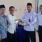 Didampingi kepala SMA Muhammadiyah 1 Jombang, Dian Sukarno menyerahkan buku karyanya kepada pengawas