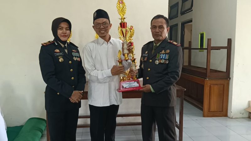 Kepala MIM 10 Jombang, Annas Fauzi menunjukkan tropy juara lomba gerak jalan yang diperoleh siswa-siswinya
